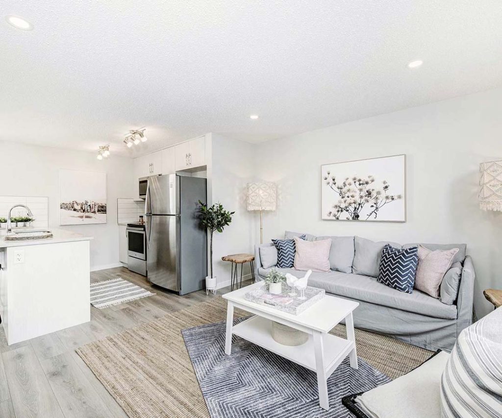 Bright open-concept living room and kitchen in ZEN Abrio Empire townhouse with light finishes and cozy decor.