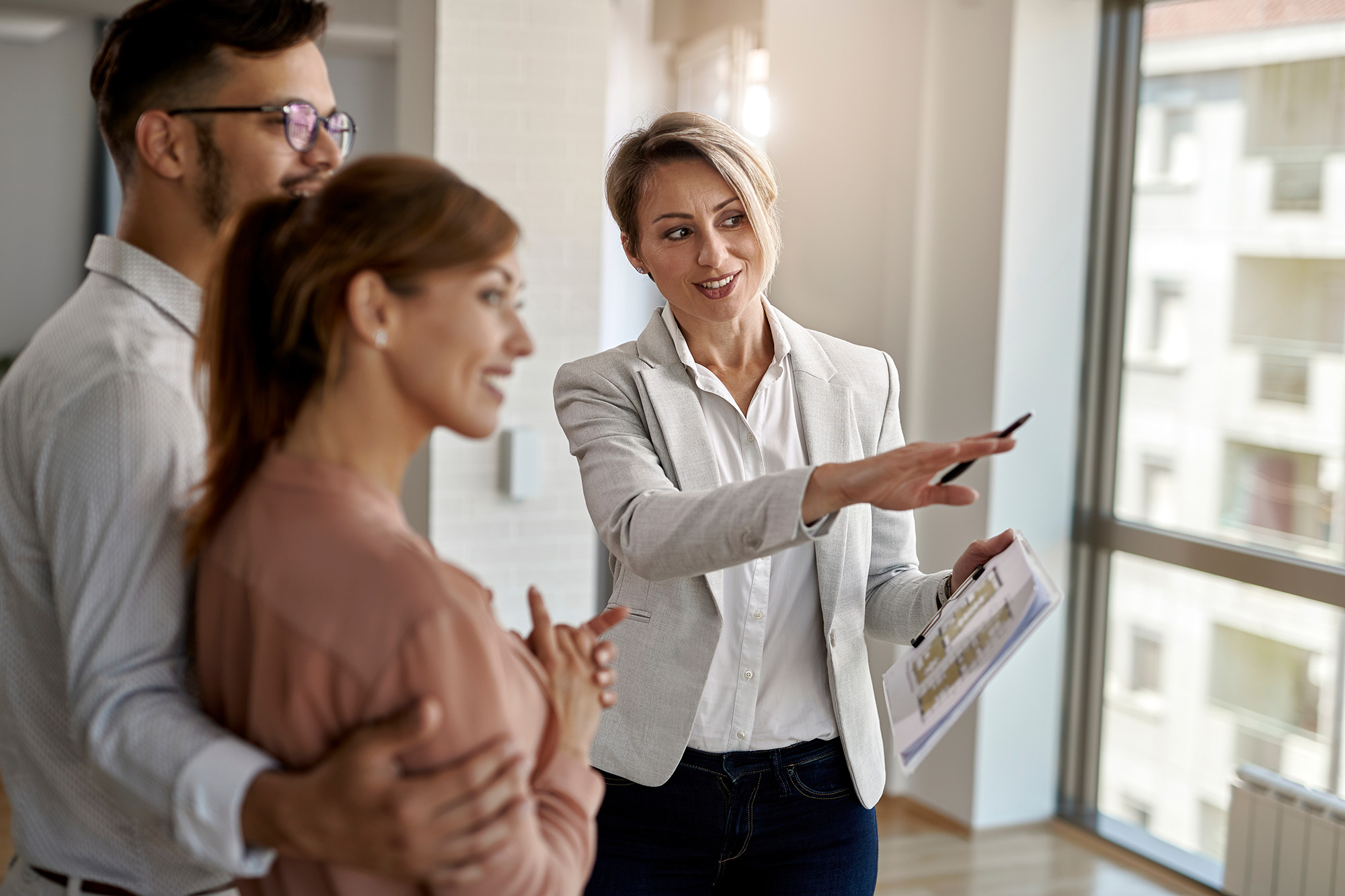 Realtor showing happy couple a property