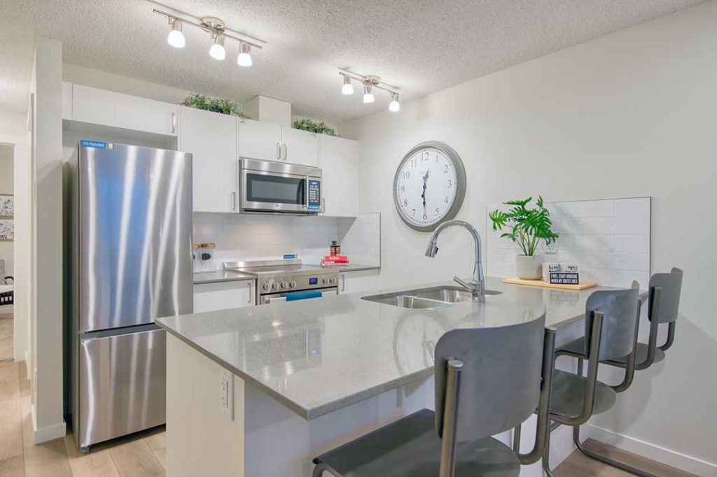 kitchen with white cabinets, grey quartz countertop and stainless steel appliance